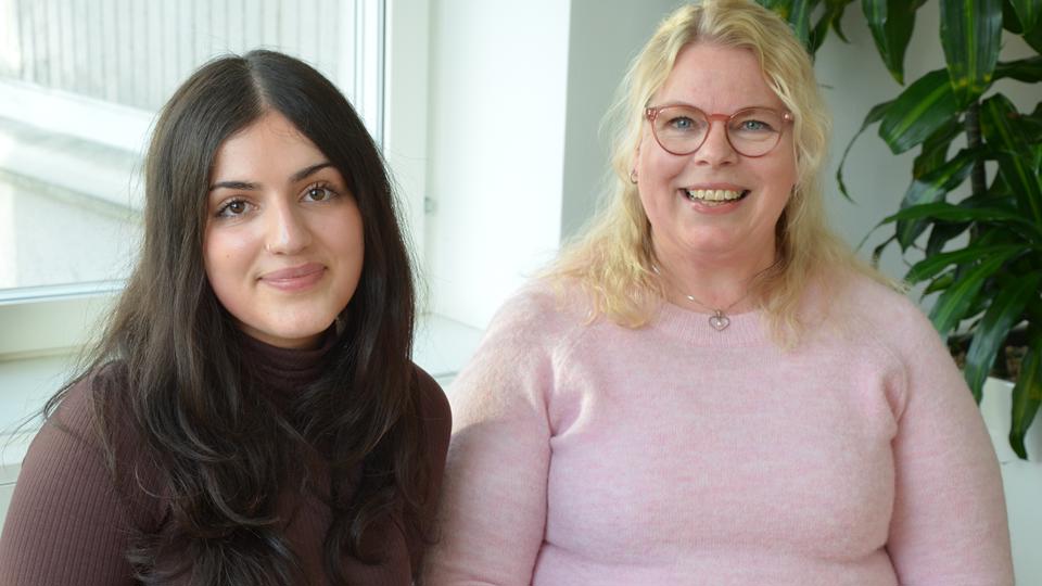 Två kvinnor som tittar in i kameran och ler, halvporträtt, fotografisk bild