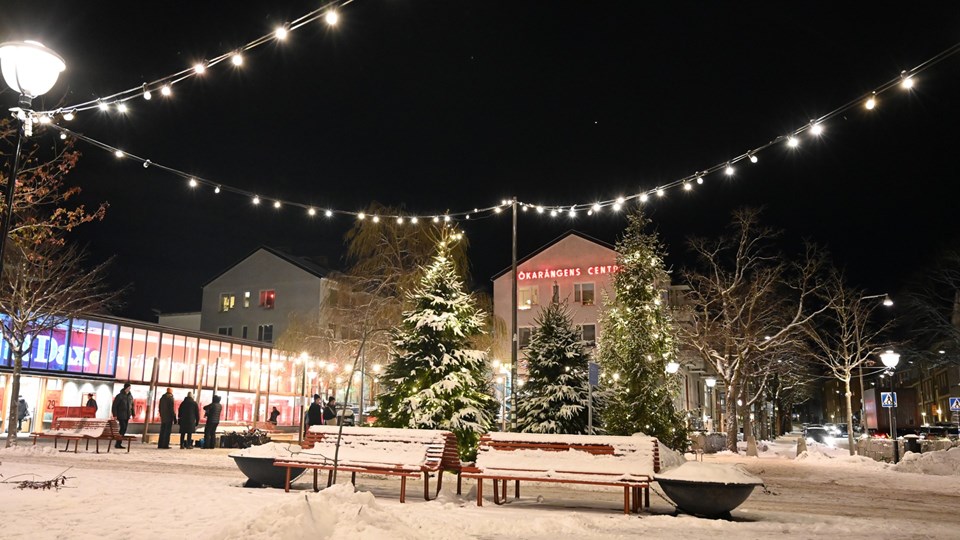 Ett snötäckt torg utanför Hökarängens centrum  som har fotograferats på kvällen.