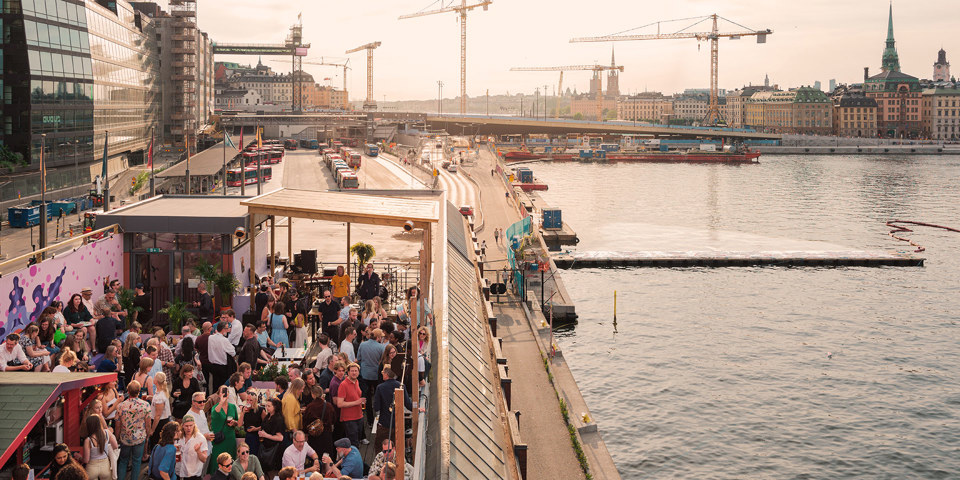 Många människor på en takterass med utsikt över Stockholm 