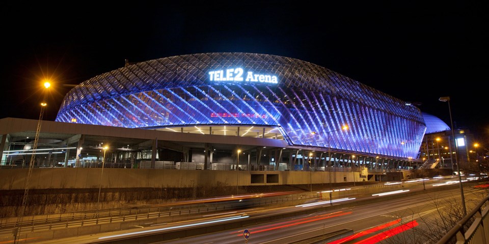 Tele2 arena upplyst under kvällstid. Foto.