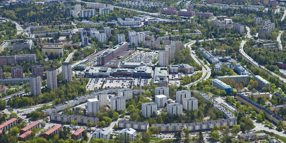 Flygfotografi över Farsta stadsdelsområde med träd och bebyggelse.