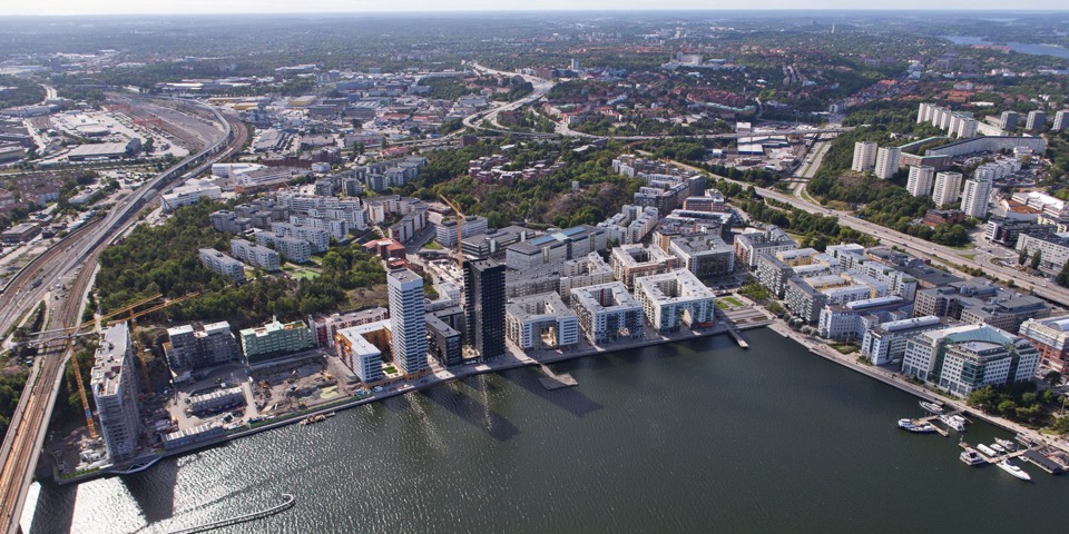 Flygfoto över bebyggelse, vatten, en bro och tågspår.