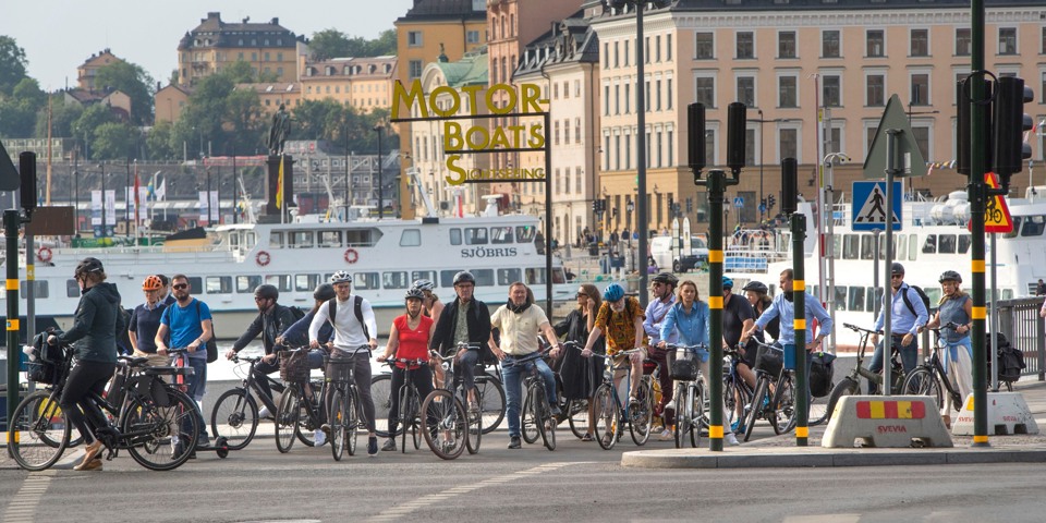 Cyklister väntar vid övergångsställe.