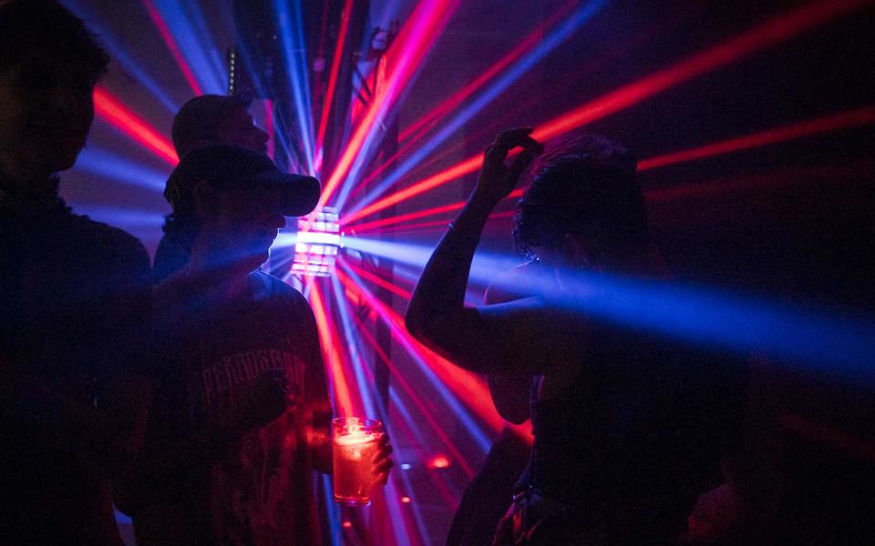 Personer dansar på ett dansgolv med färgglada strålkastare