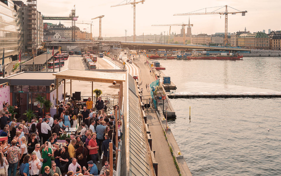 Många människor på en takterass med utsikt över Stockholm 