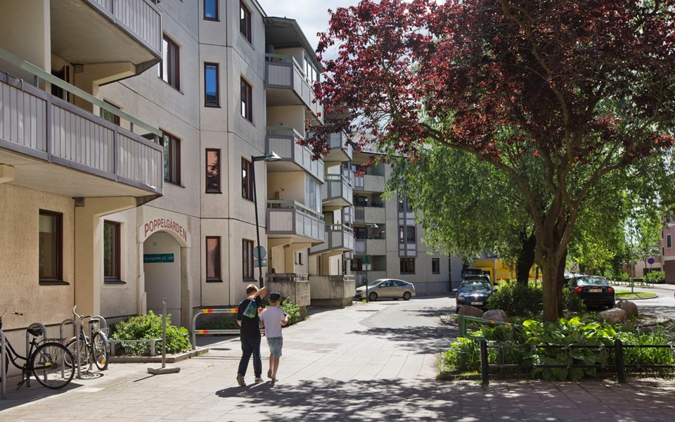 Två barn som promenerar mellan lägenhetshusen i Enskededalen. Foto.