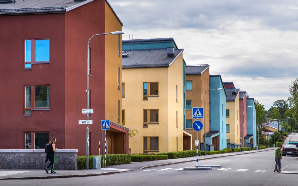 Färgglada hus längs en bilväg.