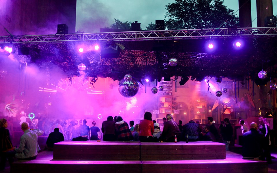 Människor sitter och samtalar och dansar på nattklubb Trädgården. Foto.